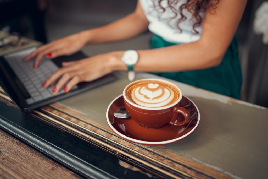 Working on a laptop with a coffee in a cafe