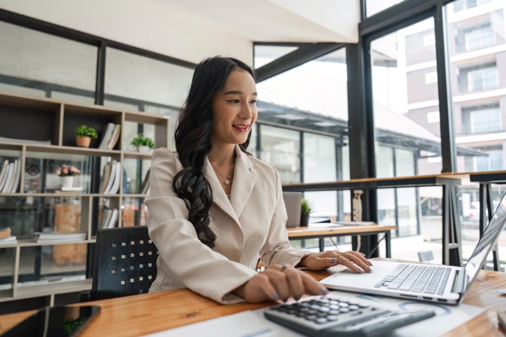 Business owner working at a laptop in a bright office