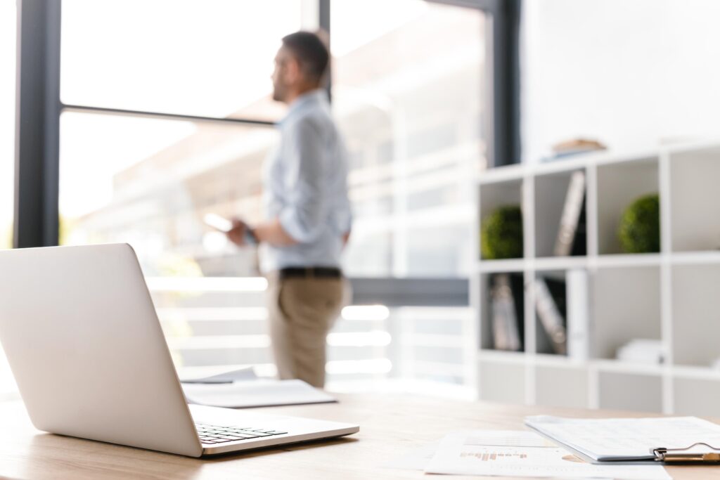 Business owner with a laptop by an office window